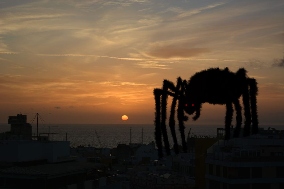 Paisaje al amanecer con una araña gigante dibujada